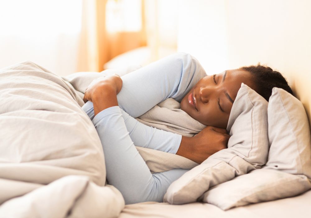 Dormitorio con luz suave, ropa de cama clara y sensación de calma mostrando una mujer que duerme profundamente, demostrando que es posible dormir mejor durante la menopausia