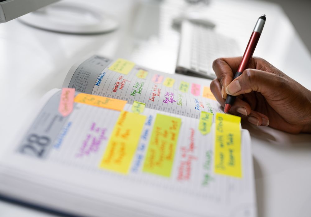 Mano escribiendo en una agenda llena de tareas, símbolo de la culpa e hiperresponsabilidad en la menopausia