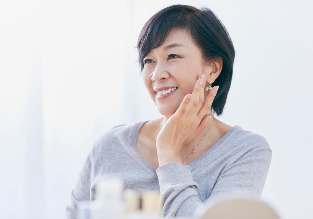 Mujer asiática sonriendo, reflexionando sobre las narrativas de la menopausia en distintas culturas