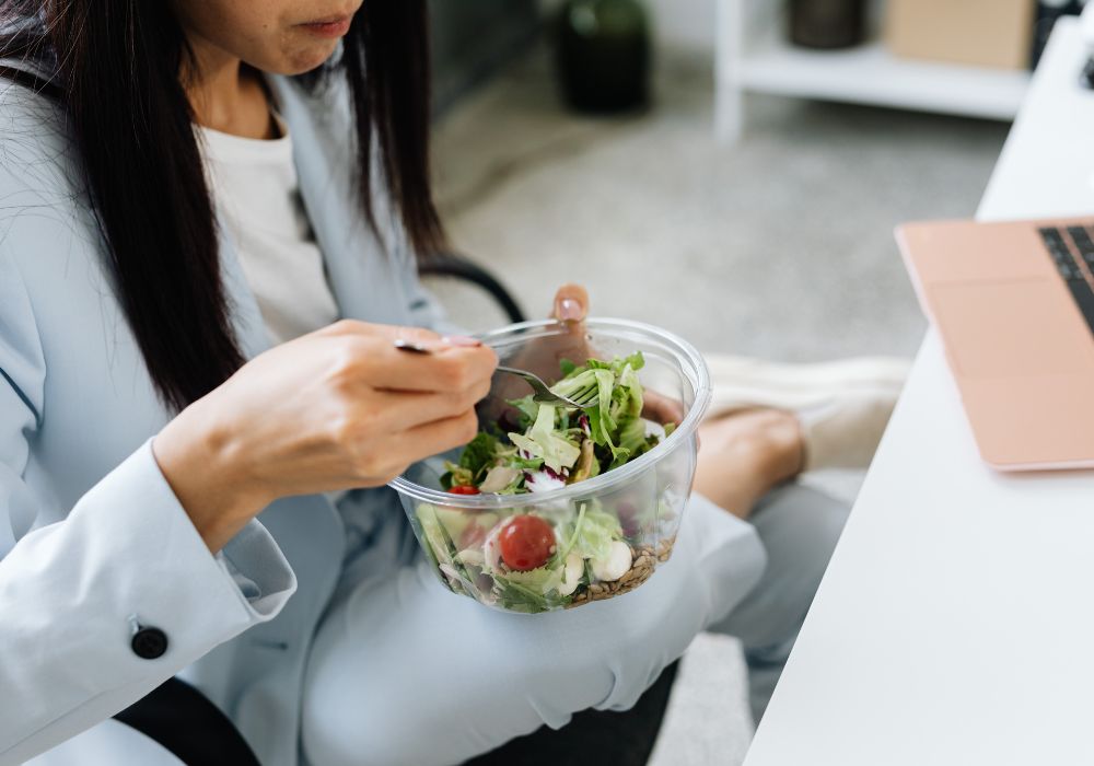 Mujer comiendo una comida equilibrada para cuidar la grasa abdominal en la menopausia
