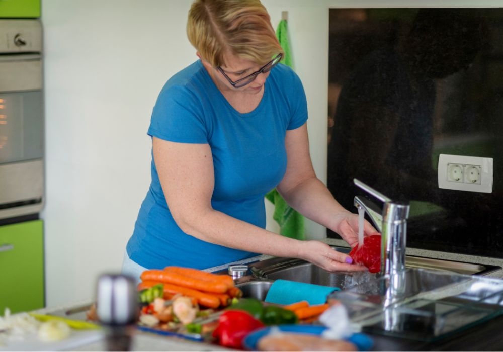 Mujer preparando alimentos que favorecen la microbiota en la menopausia